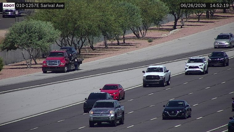 Tow truck with a car on its bed on the right shoulder