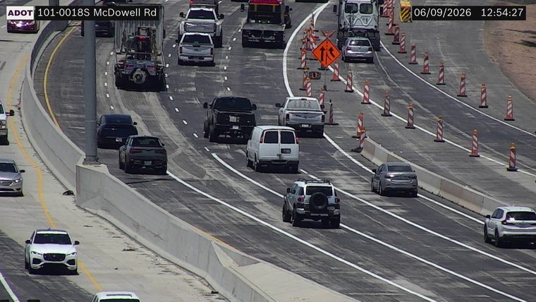 Construction cones and orange traffic barrel in the right lane