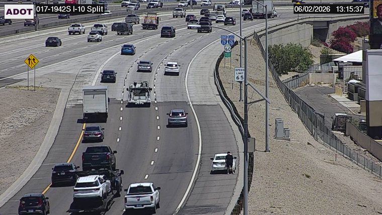 Person standing next to a white car on the right shoulder