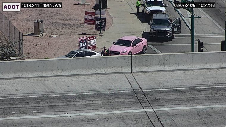 Police car with open door and person standing next to it