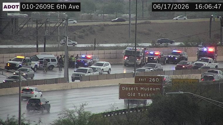 Multiple police cars and a fire truck with emergency lights on the roadway