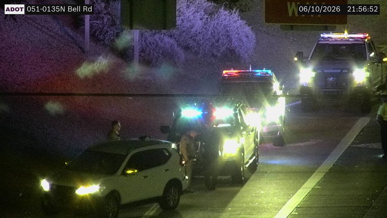 Multiple police vehicles with lights on in the right lane
