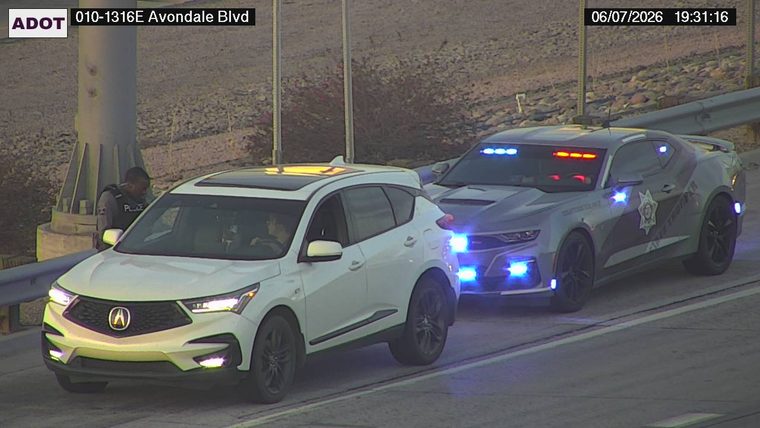 State trooper vehicle with lights on behind a white SUV in the right lane
