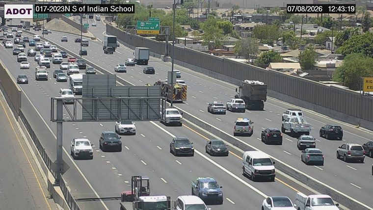 Fire truck and two police cars with lights on in the left lanes