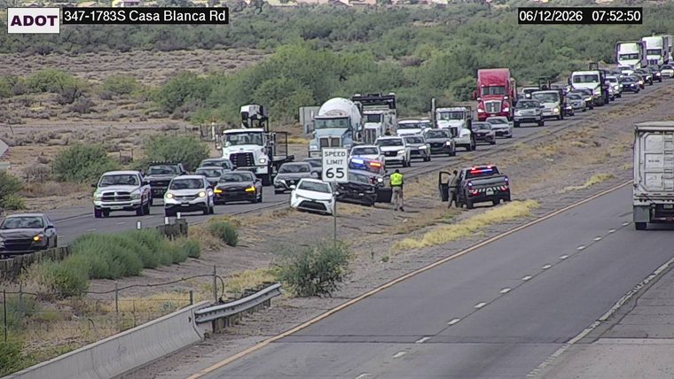 Police car and worker near a crashed vehicle in the left lane