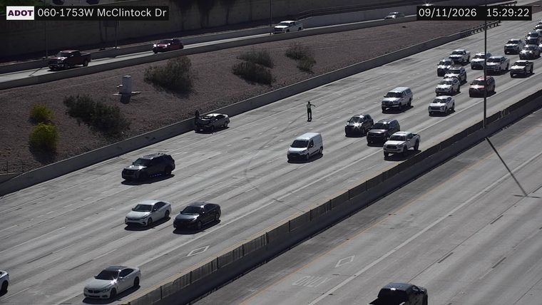 Person standing in the left lane near a damaged vehicle