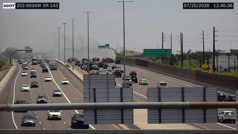 Smoke and fire in the median with multiple fire trucks and emergency vehicles present