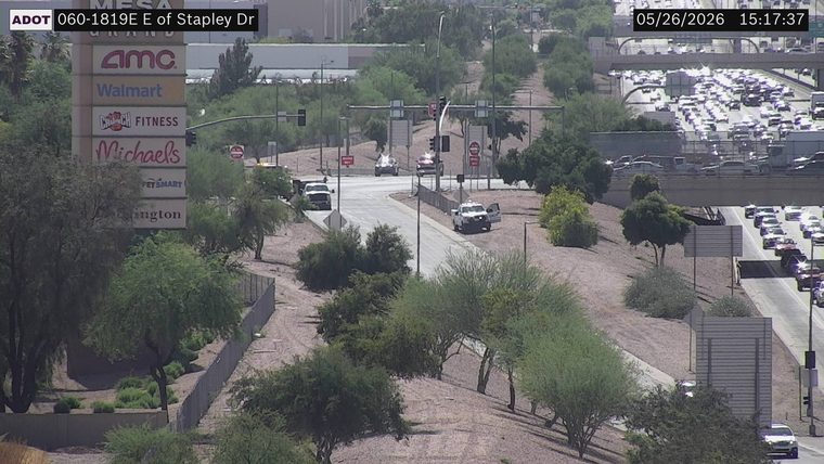 White pickup truck parked on the right dirt shoulder of the ramp with its driver-side door open