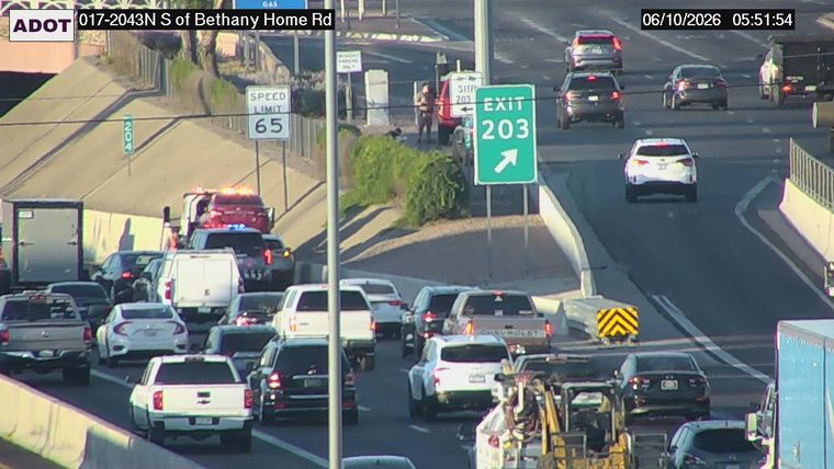 Tow truck and emergency vehicle with lights on in the left lane