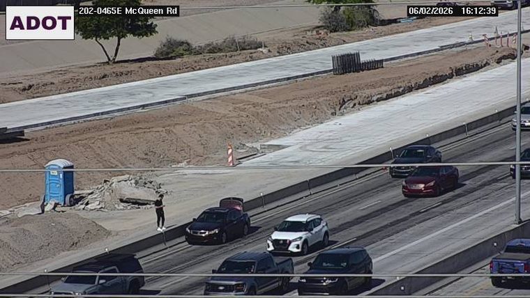 Person standing near a portable toilet on the side of the road