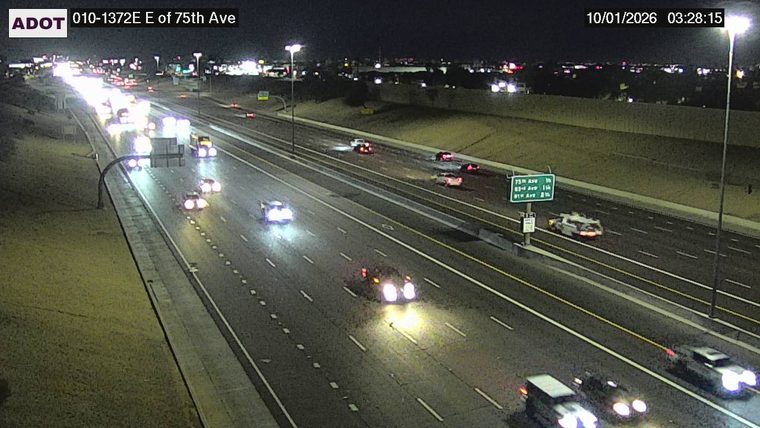 White vehicle with red and blue flashing lights on the right shoulder