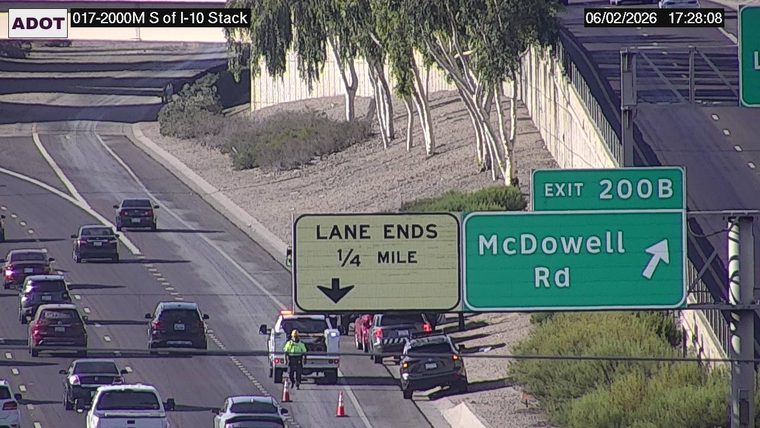 Tow truck and worker in the right lane with cones