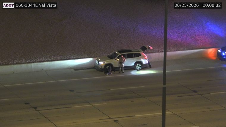Police car with red and blue lights on the right shoulder