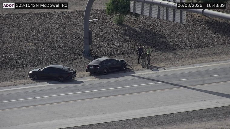 Two people and a damaged car on the right shoulder