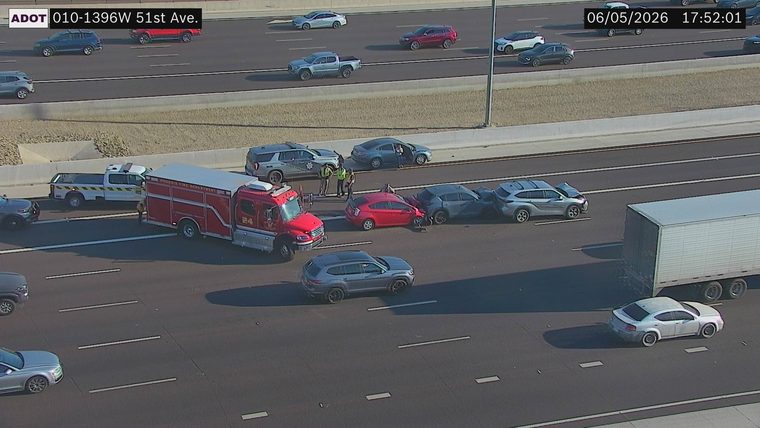 Multiple vehicles collided in the left lanes, with a fire truck and police vehicle on scene