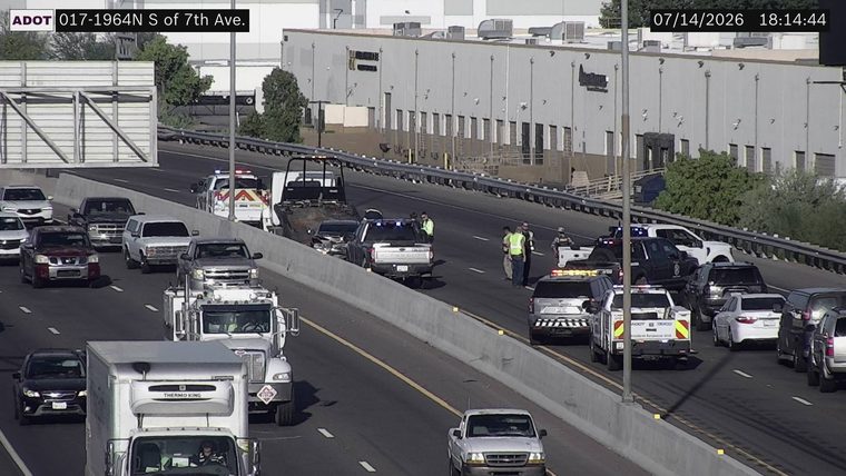 Multiple police vehicles and an ADOT incident response truck with lights on in the right lanes