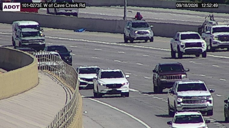 Person on top of a vehicle in the middle lane