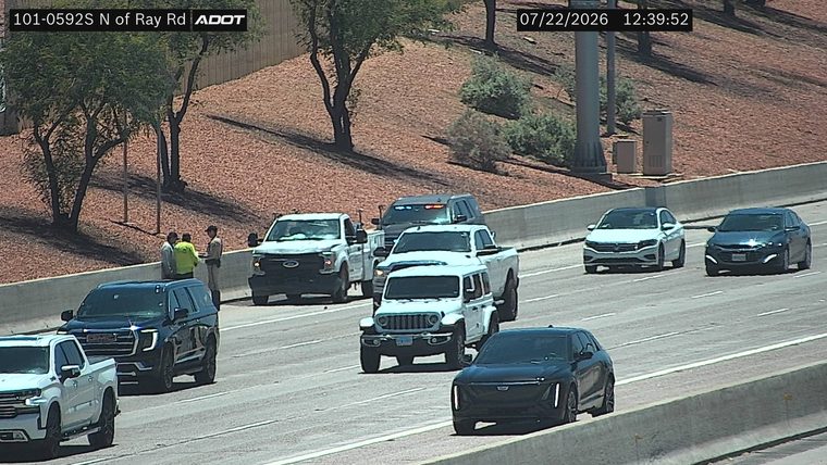 Three individuals and two vehicles on the right shoulder