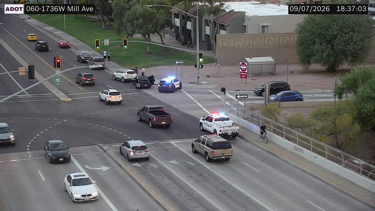 Two police cars with lights on at an intersection