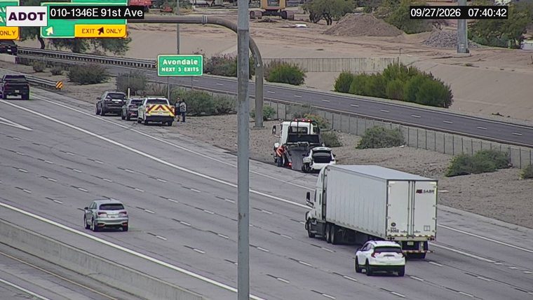 Tow truck assisting a white car on the right shoulder