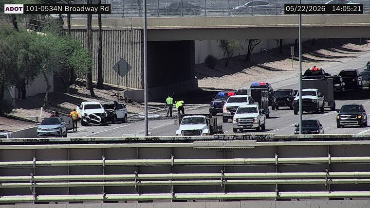 Two-vehicle crash on the left shoulder with emergency responders and police vehicles with flashing lights in the travel lanes
