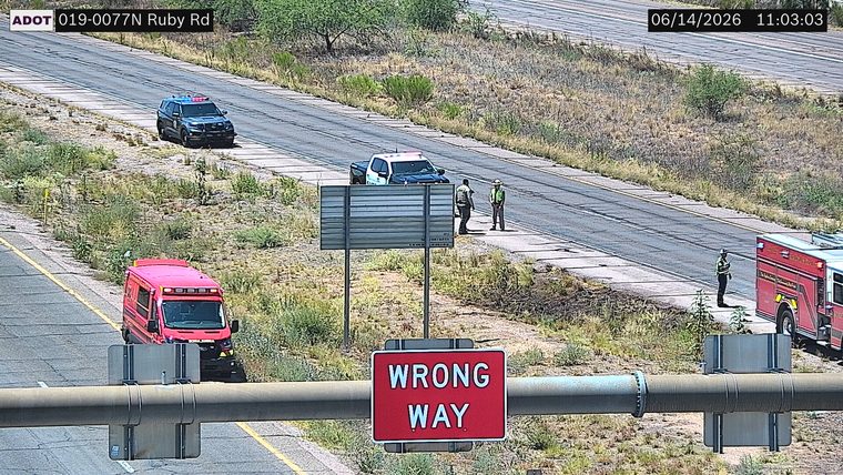 Fire truck and ambulance on the shoulder with two police officers and a person in a safety vest