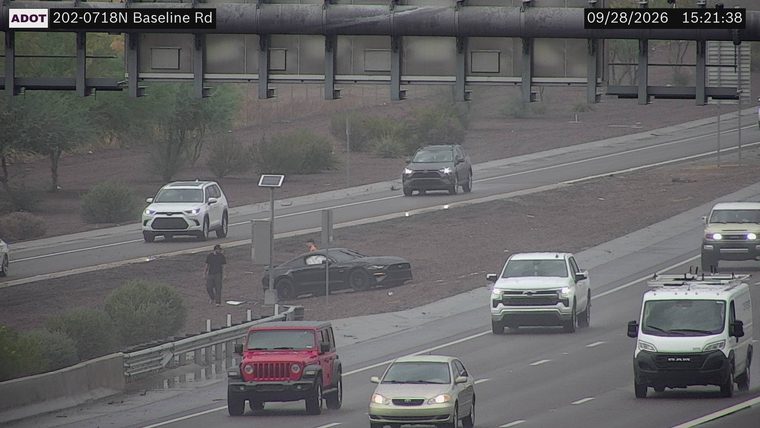 Black sports car off the roadway with a person standing nearby