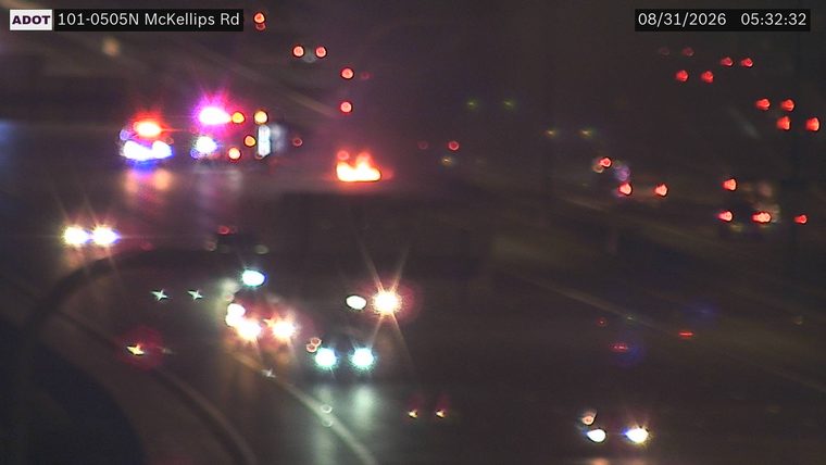 Multiple emergency vehicles with red and blue lights and a vehicle fire in the roadway