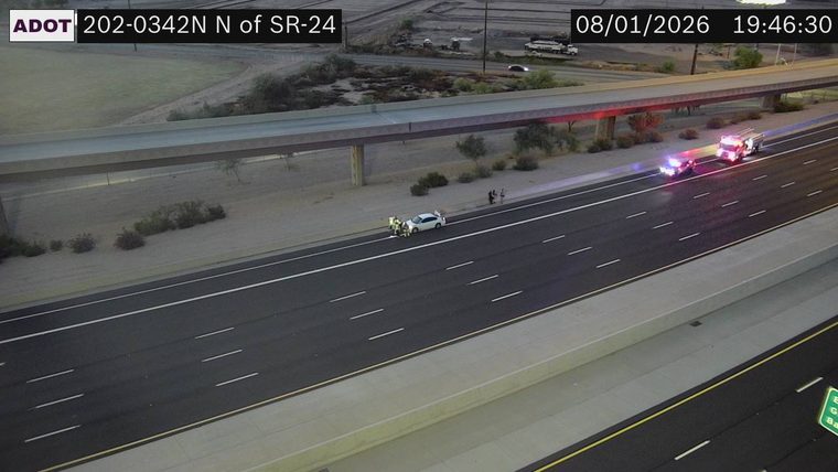 Police car and fire truck with red and blue lights on the right shoulder