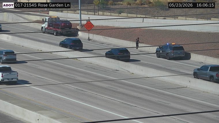 Police car with emergency lights on and a tow truck on the right shoulder