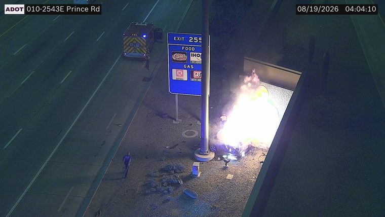 Vehicle on fire next to gas station sign