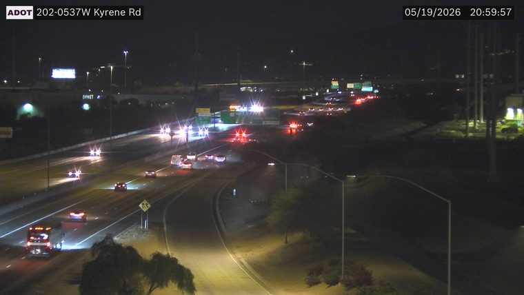 Multiple emergency responder vehicles with flashing lights blocking lanes in the center of the highway