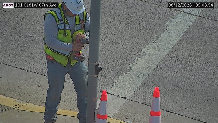 Construction worker with drill near traffic cones
