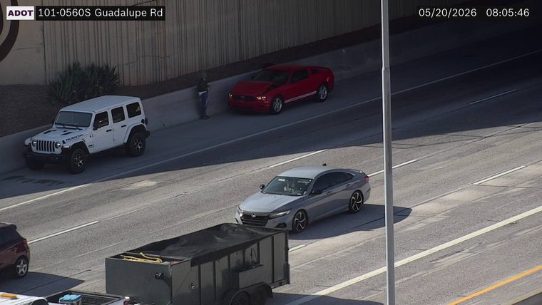 Disabled red coupe with its hood popped and a white SUV on the left shoulder with a person standing outside