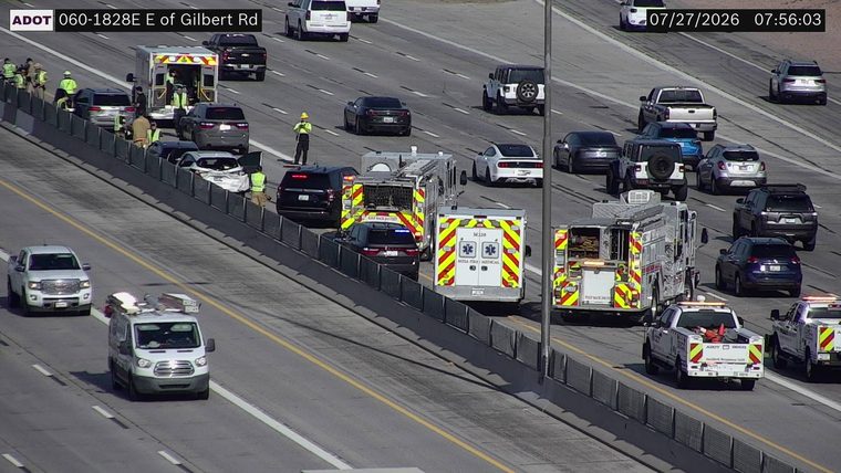 Multiple emergency vehicles and personnel on the right shoulder near a damaged white car