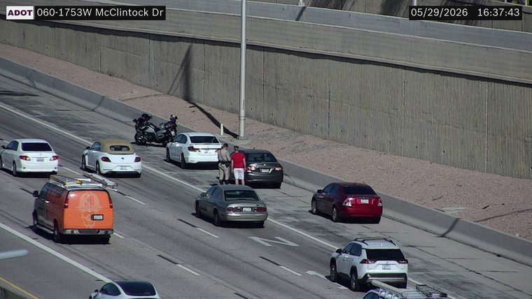 Police officer talking to a person next to a car in the right lane