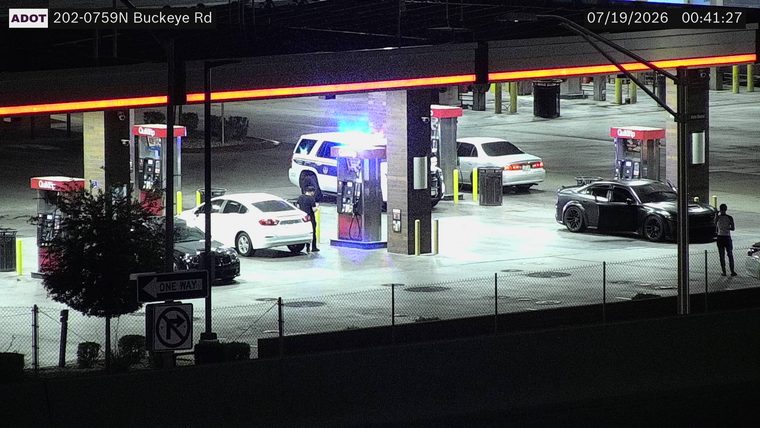Police SUV with blue and red lights on at gas pumps