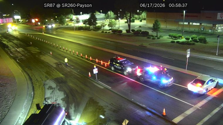 Two police cars with emergency lights on in the right lane