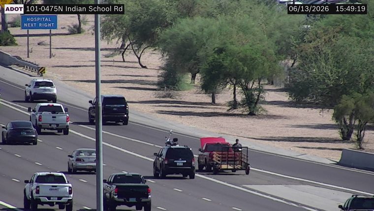 Red pickup truck with hood up and trailer in the right lane