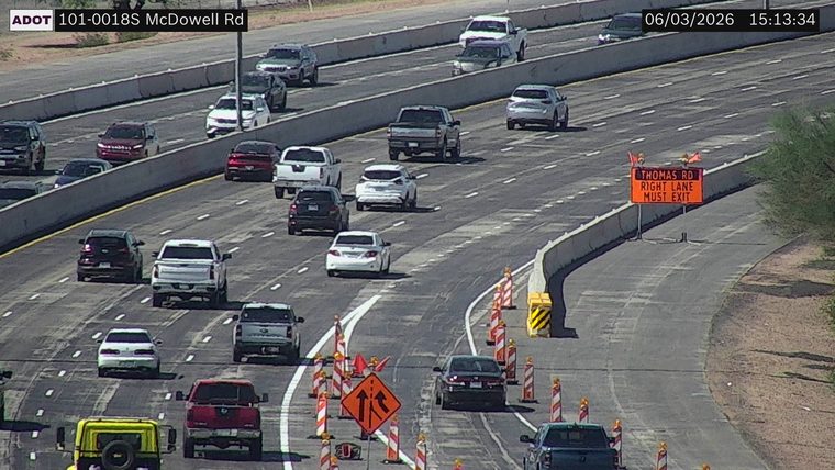 Construction cones and a 'Thomas Rd Right Lane Must Exit' sign in the right lane