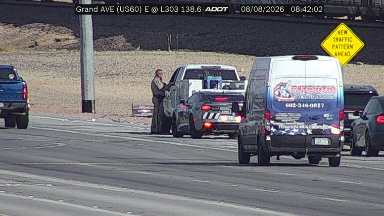Person in uniform standing next to a car on the right shoulder