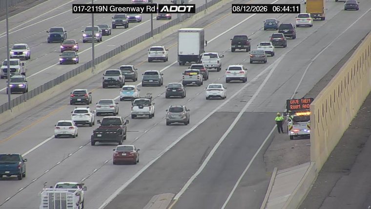 ADOT vehicle with a message board and a worker on the right shoulder