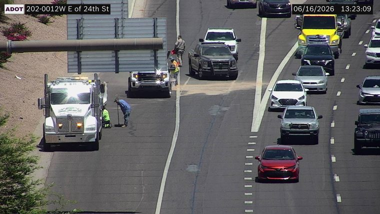 Two workers cleaning up debris in the right lane