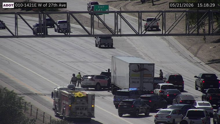 Collision between a white SUV and a box truck in the travel lanes, with a fire truck, police vehicle with flashing lights, and responders on scene