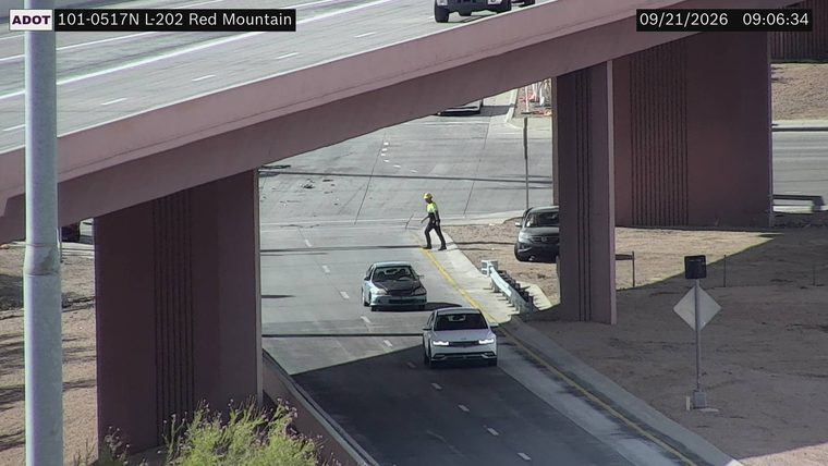 Worker in high-visibility vest and hard hat on the roadway shoulder