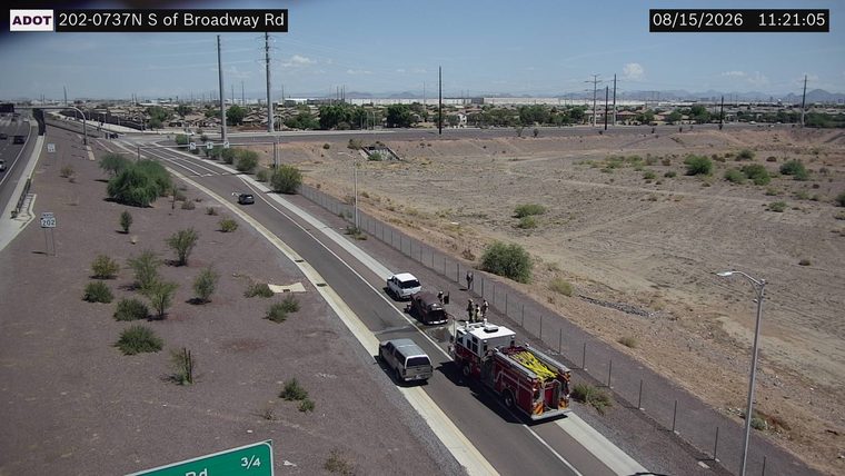 Fire truck and several people on the right shoulder near two vehicles