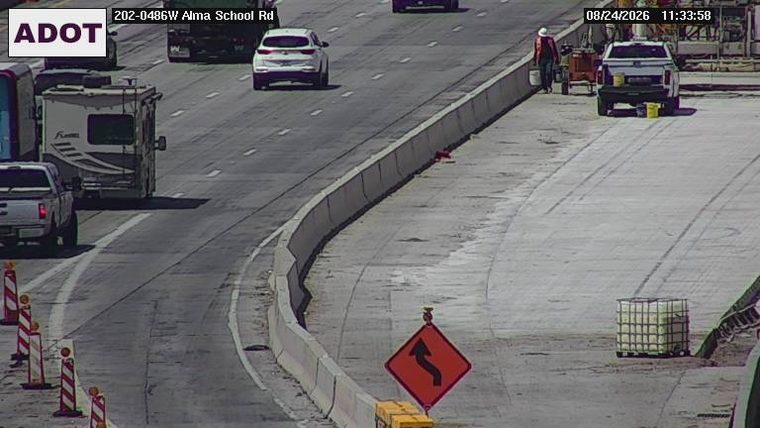 Construction worker and equipment on the right side of the roadway