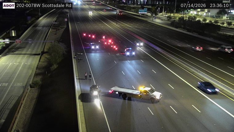 Two police cars with red and blue lights on, and multiple debris items in the roadway