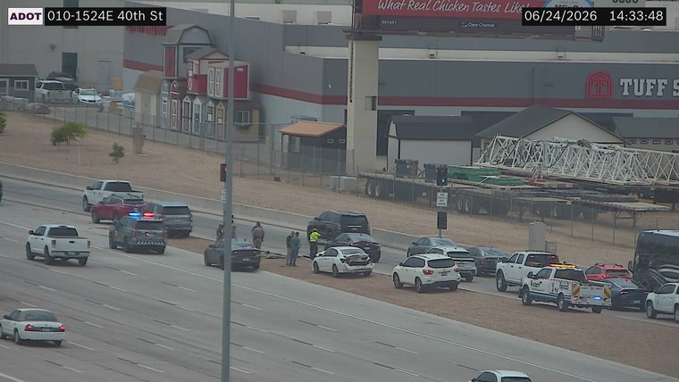 Police car with lights on the shoulder next to two damaged vehicles