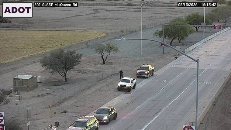 Person standing next to a white pickup truck on the right shoulder